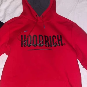 Röd hoodie från Hoodrich - Säljer en snygg röd hoodie från Hoodrich med svart logotyp på bröstet och ryggen. Hoodien har en justerbar huva med dragsko och en stor ficka framtill. Perfekt för en casual look. Tröjan är i storlek S och byxorna är i storlek M. Hela settet för 600, tröjan 300 och byxorna 300