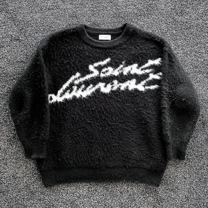 Saint Laurent stickad tröja - Svart Saint Laurent tröja i fluffig bomull med vit, stor logotyp framtill. Rund halsringning och långa ärmar. Oversized vibe och riktigt skön textur som sticker ut. Skick 8/10 använd men inga defekter :). Storlek L, pris går att diskutera✅