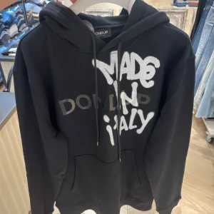Svart hoodie från Dondup  - Svart hoodie från Dondup med stor vit och grå text på bröstet där det står 'MADE IN ITALY'. Tröjan är helt ny och är helt slutsåld!