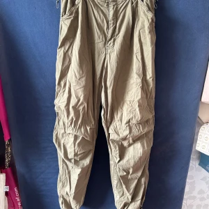 Khakigröna cargobyxor från Bershka - Säljer ett par khakigröna cargopants från Bershka i storlek M. Byxorna har dragsko i midjan och vid bensluten, samt flera fickor och en loose passform. Säljer för att jag personligen bytt stil.