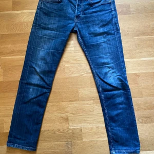 Blå Lee jeans straight fit - Snygga blå jeans från Lee med klassisk femficksdesign och raka ben. Jeansen har mellanblå tvätt med lätt slitning och Lee-läderpatch bak i midjan. Perfekta för dig som gillar en tidlös look och vill ha ett par jeans som funkar till allt.