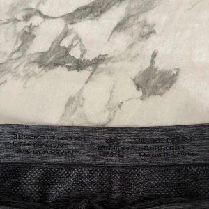 Mörkgrå träningsshorts från Ronhill - Supersköna mörkgrå träningsshorts från Ronhill i stretchigt material. De är tillverkade av polyester och elastan, har en tight passform och är perfekta för gymmet eller löpning. Jag är vanligtvis storlek S men de passar mig också.