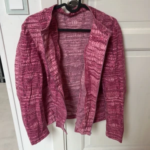 Rosa mönstrad jacka med croco-look - Säljer en unik rosa jacka med croco-inspirerat mönster. Perfekt för dig som vill sticka ut med en cool och färgstark stil. Storleken skulle jag uppskatta är storlek m!