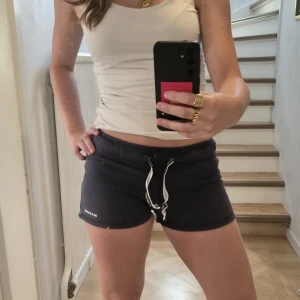 Mörkblå shorts från Marine - Supersköna mörkblå shorts från Marine med vit snörning i midjan och broderad logga på benet. Ser ganska små ut men de är väldigt stretchiga, jag själv har använt dessa många år! Stl xs, 32/34.