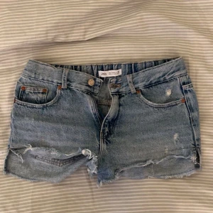 jeansshorts från Zara med slitningar  - Snygga jeanshorts från Zara med slitningar står dem är i stolek 152, men dem passar mig bra och jag har 36/38 vanliga fall!
