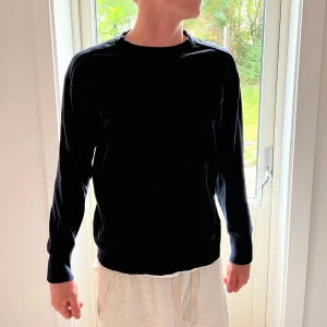 Mörkblå sweatshirt från GANT - Säljer en mörkblå sweatshirt från GANT i relaxed fit. Tröjan har rund halsringning med ribbade detaljer och en liten broderad GANT-logga på bröstet. Perfekt basic med långa ärmar och mjukt bomullsmaterial.