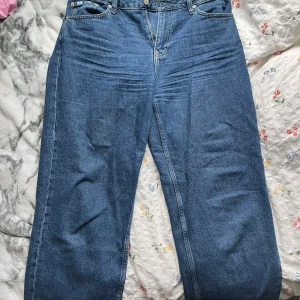 Calvin Klein 90s Straight jeans blå W30 - Säljer ett par klassiska blå jeans från Calvin Klein Jeans i modellen 90s Straight. Jeansen har rak passform, normal midja och fem fickor. Tillverkade i robust denim med snygg tvätt och ikonisk CK-patch bak i midjan.