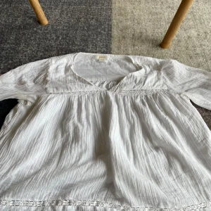 En vit blus ifrån Gina - En fin vit blus ifrån Gina med fina detaljer och armar. Luftig och skön. Den är lite mer lös i passformen. Storlek 158/164