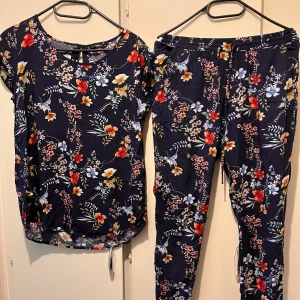 Byxor och blus strl 38 - Blommigt set med byxor och blus från Only onlNOVA AOP i strl 38. Byxorna har resår i midjan och fickor framtill. Material: viskos  Mycket fint skick.  