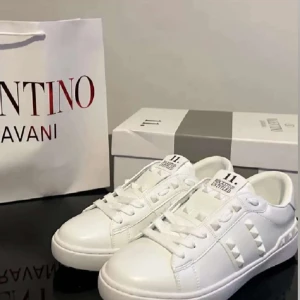 Valentino Garavani vita Rockstud sneakers - Nya vita Valentino Garavani Rockstud sneakers i skinn med ikoniska nitar längs sidorna och baktill. Kommer med originalkartong och påse. Storlek 39 men små i storleken och passade inte, snarare 38 1/2. 