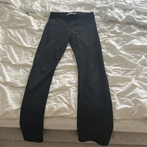 Svarta bootcut byxor från 157 XS - Svarta bootcut byxor från lager 157 i storlek XS. Byxorna har låg midja och , mjukt material som sitter skönt. Snygg passform med utsvängda ben som ger en trendig siluett. Perfekta för dig som gillar stilrena plagg.