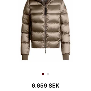 Beige para jumper jacka (pjs) - Snygg beige pufferjacka med glansig finish och raka linjer. Jackan har ribbade muddar, huva och en rejäl dragkedja framtill. Perfekt för dig som vill ha en varm och trendig look under kyliga dagar. Passar både Xs och S