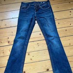 Miss Me jeans  - Snygga blå jeans från Miss Me med broderade bakfickor, nitar och dekorativa sömmar. Bootcut-modell med låg midja. Säljer då de tyvärr inte passar längre