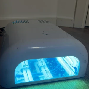 UV-lampa för naglar  - UV-lampa i vit plast med blått ljus, perfekt för att härda gelnaglar. Maskinen har timerfunktion för 90, 120 sekunder och 30 minuter. Utrustad med flera lysrör och enkel on/off-knapp. Passar dig som vill fixa snygga naglar hemma.