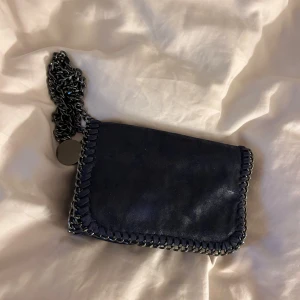 Handväska - Säljer denna marinblåa Stella McCartney inspirerade lilla väska. Man kan ha den som axelremsväska då den har ett långt band men också som en kuvertväska❣️Bra skick men några få defekter.