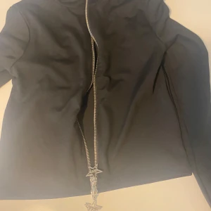 Svart jacka med stjärn-dragkedja - Svart  kofta med  med lång ärm och unik dragkedja framtill med stora stjärnformade .