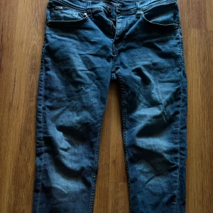 Blå jeans från Lindbergh - Snygga blå jeans från Lindbergh med klassisk femficksdesign och raka bakfickor. Jeansen har en normal passform och är tillverkade i mjukt denimtyg. Perfekta för dig som gillar en enkel och stilren look.