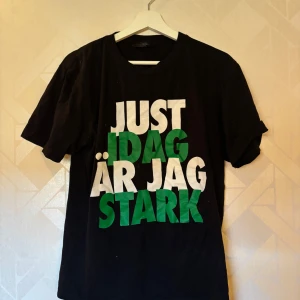 Hammarby T-shirt  - Hammarby T-shirt i bomull med stort tryck på framsidan: 'Just idag är jag stark' i vitt och grönt. Storlek M