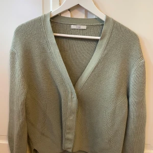 Ljusgrön ribbad kofta från Zooc - Snygg ljusgrön kofta från Zooc i ribbstickad bomull. Koftan har v-ringning, långa ärmar och breda muddar. 