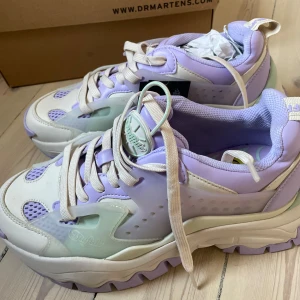 Buffalo chunky sneakers i lila och vitt - Helt nya med prislapp. Buffalo sneakers med chunky sula i lila och vitt, detaljer i mintgrönt och meshpartier. Skorna har snörning och en plattformssula som ger extra höjd. Strl 40. 