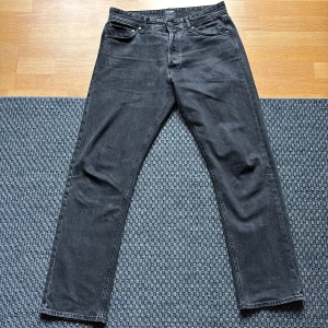 Svarta loose fit jeans Jack & Jones - Säljer ett par svarta jeans från Jack & Jones i modellen Loose/Chris. De har loose fit, raka ben och klassisk femficksdesign. Jeansen är tillverkade i denim och har en snygg mörk tvätt. Perfekta för dig som gillar avslappnad stil.