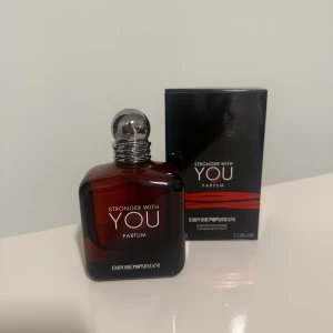 Emporio Armani Stronger With You Parfum - Emporio Armani Stronger With You Parfum i en mörkröd glasflaska med silverfärgad rund kork. Flaskan rymmer 100 ml och har en stilren, maskulin design. Kommer med original svart kartong med röda detaljer. Perfekt för dig som gillar exklusiva dofter.