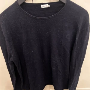 Mörkblå stickad tröja Filippa K - En stilren mörkblå stickad tröja från Filippa K med rund halsringning och långa ärmar. Tröjan har en klassisk passform och är perfekt för casual look. Enkel och tidlös design som funkar till det mesta.