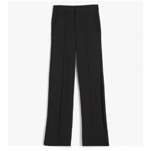 Svarta kostymbyxor med pressveck (low waist) - Snygga svarta kostymbyxor med raka ben och markerade pressveck. Byxorna har hällor för bälte, sidfickor och en klassisk midja. Perfekta för en clean och stilren look, passar till både sneakers och boots. omsydda till low waist och passar xs (strl 170)