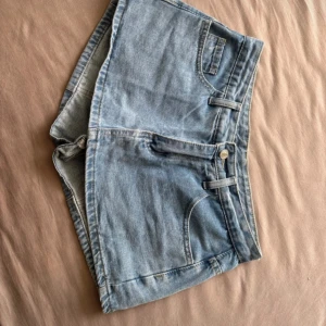 Ljusblå jeansshorts/kjol med midrise midja - Snygga ljusblå jeans kjol från framsidan och shorts från baksidan