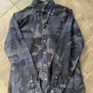 Ralph Lauren skjorta - Sällsynt skjorta från Ralph Lauren i camo-mönster⁉️ Skjortan är i bomull med klassisk passform och broderad logga framtill. Nypris: 1500 kr ❗ Mitt pris: 450 kr 💸 (kan diskuteras!) Bra skick och perfekt för dig som gillar unik stil. Hör av dig om du har frågor eller vill se fler bilder!😄✅