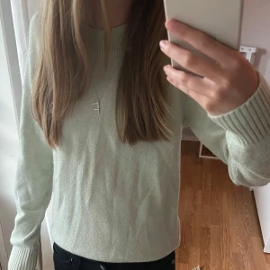 Ljusgrön stickad tröja - Jättefin och skön ljusgrön stickad tröja lik den från Vero Moda. Tröjan är i storlek XS. Den har rund halsringning och breda ribbade muddar vid ärmslut och nederkant. Passar perfekt för sommarkvällar, höst och vinter. Säljer även en likadan i gul! Skriv om ni har frågor!
