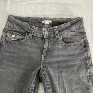 Grå jeans från Gina Tricot, storlek 170 - Säljer mina gråa jeans ifrån Gina Young i storlek 170 då dem inte används. Byxorna har låg/medelhög midja. De har knapp fickor på baksidan och är använda 2 gånger. Inga defekter! Vid frågor eller prisförslag är de bara att skicka🥰