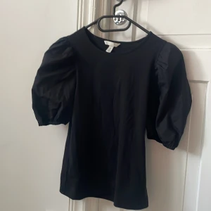 Svart blus med puffärmar från H&M - Svart volang t shirt från hm. Aldrig använd.
