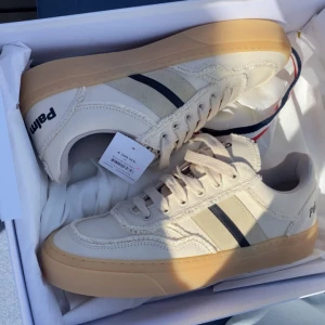 Palm Angels x Moncler sneakers beige - Splitter nya skor med kvitto köpte de men kunde tyvärr inte ha de                                                                    Stig in i stilen med Monclers vita sneakers, en framstående del från samarbetet Moncler x Palm Angels, perfekt för att lyfta vilken avslappnad outfit som helst. Viktiga egenskaper: Elfenben | Canvasöverdel med randiga sidoband i mocka | Snörning framtill | Rund tå | Kontrasterande logotyp på tungan och hälen | Logopatch baktill | Material och skötsel: 100% bomull