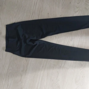 Svarta leggings från Bonatti, stl L - Svarta leggings från Bonatti i storlek L. Tillverkade i stretchigt material med 80% polyamid och 20% elastan, vilket gör dem riktigt bekväma och följsamma. Perfekta för träning eller chill dagar. Hög midja för extra komfort.