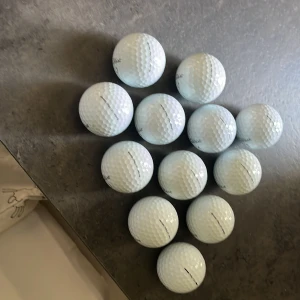 Pro v1 golfbollar (12-pack) - Ett 12-pack golfbollar från Titleist, perfekt för dig som vill ta ditt golfspel till nästa nivå. Bollarna är märkta med olika siffror och är i fint skick. Passar både nybörjare och erfarna golfare som vill ha kvalitet på banan.