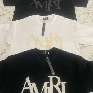 AMIRI t-shirt med stor logga - Säljer en snygg AMIRI t-shirt i bomull med stor logga framtill. Finns i svart och vit med kontrasterande tryck. Klassisk rund hals och korta ärmar. Perfekt för dig som gillar streetwear och vill sticka ut med en exklusiv look.