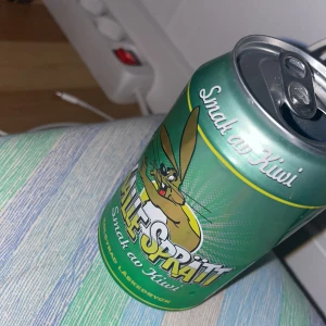 Kalles Sprätt Smak av Kiwi - En kolsyrad dryck med smak av kiwi. Färgglad burk med tecknad kanin på framsidan. Perfekt för dig som gillar fruktiga och roliga drycker. Passar utmärkt till fest eller som törstsläckare när du vill ha något annorlunda.