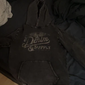 Svart hoodie från Denim & Supply Ralph Lauren - Säljer en svart hoodie från Denim & Supply Ralph Lauren i storlek M !!!!!PASSAR DOCK SOM EN L!!!!!!Tröjan har tryckt logga framtill, huva och en stor magficka. Perfekt för en avslappnad stil och passar till det mesta.