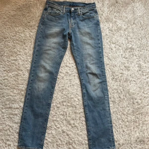 Levi's 511 blå jeans - Säljer ett par klassiska blå Levi's 511 jeans med normal passform och raka ben. Jeansen har fem fickor, dragkedja och knapp i midjan. Perfekta för dig som gillar en tidlös stil. Midjemått W28 och längd L32.