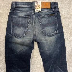 Nudie Jeans - Tja! Säljer dessa helt nya grå/mörkblå Nudie jeans med fet tvätt! Jeansen är helt nya med lapparna kvar och i perfekt skick. Size 28/32. Skriv vid funderingar!