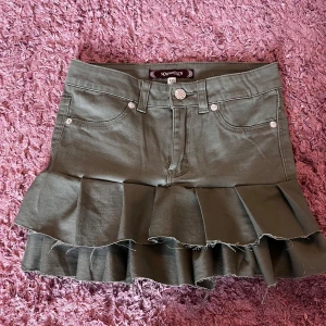 Grön volangkjol från Now and Then - Säljer en grön kortkjol som jag sytt själv hemma. Kjolen är strl xxs men skulle passa bättre på en  xxxs/134-146.💓.                                                                ‼️OBS säljer åt en kompis så lite svårt att mäta mått och skicka bilder men försöker mitt bästa‼️ 