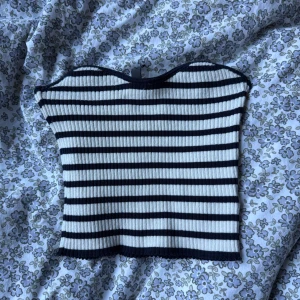 Randig ribbad tubtopp  - Säljer en ribbad tubtopp från H&M divided i svart/mörkblått och vitt. Toppen har ett randigt mönster och är croppad, perfekt för sommaren. Den är stretchig och använd max 2 gånger 💕💕 