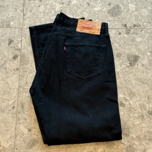 Svarta Levi's 501 jeans W36 L30 - Klassiska svarta Levi's 501 jeans med raka ben. Storlek W36, L30. Väldigt snygga jeans enligt mig och är i jätte bra skick. Nypriset ligger på cirka 1400 så ett väldigt bra pris.