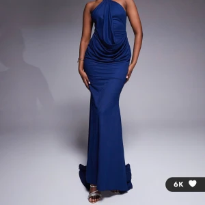 Marinblå långklänning  - säljer en elegant marinblå långklänning med halterneck och snygg drapering framtill. klänningen har en metallring vid halsen och smala axelband som korsas i ryggen. perfekt för speciella tillfällen när du vill sticka ut. en ny klänning kostar 969kr och säljer min för 700