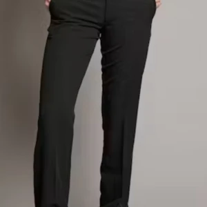 Svarta kostymbyxor från Bikbok - Snygga svarta kostymbyxor med normal passform och vida ben. Byxorna har låg midja och diskreta fickor bak. Perfekta till en stilren look och passar till många olika outfits. 