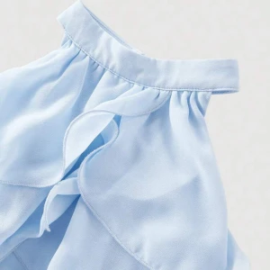 Ljusblå volangblus med halterneck - Supersöt ljusblå blus med halterneck och flera lager volanger. Blusen har en elegant knäppning i nacken med pärldetalj och är ärmlös. Perfekt för sommarens alla tillfällen när du vill känna dig extra fin.