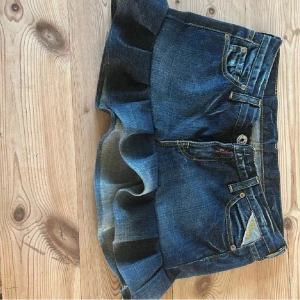 Jeanskjol med volang  - Säljer en jeanskjol som är köpt här på plick som tyvärr var för stor. Den är omsydd av förra ägaren. 