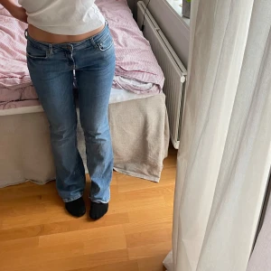 Blå bootcut jeans från Zara - Säljer ett par klassiska blå bootcut jeans från Zara med normal passform. Jeansen har fem fickor, bälteshällor och stängs med knapp och dragkedja. Perfekta till vardags för en avslappnad men snygg look.