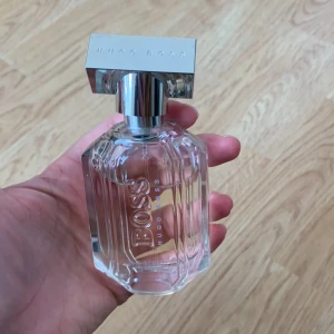 BOSS The Scent Eau de Parfum från Hugo Boss - Elegant parfymflaska från Hugo Boss, BOSS The Scent. Flaskan är transparent med räfflade kanter och har ett silvrigt metallock med märkets logga ingraverad. Tjejig doft, men inte för mig :) 